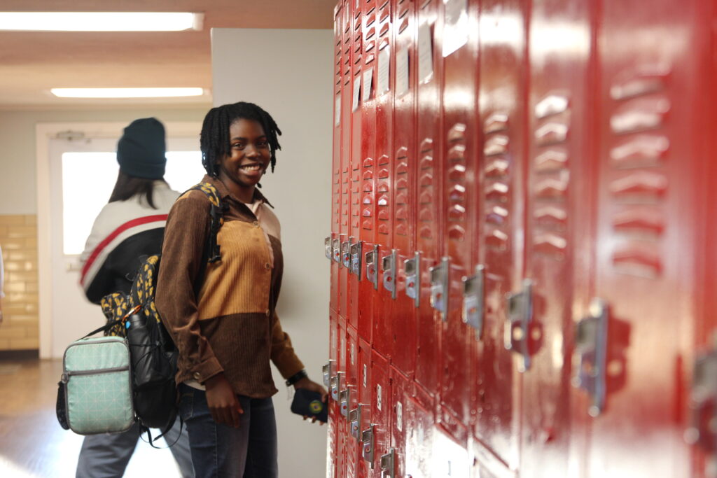 Christian Heritage School hallway with girl standing at locker carrying a backpack